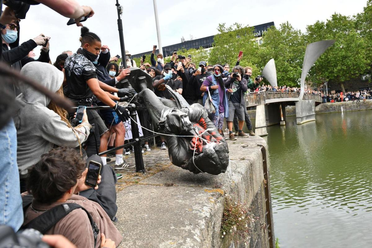 Manifestanti a Bristol con la statua abbattuta dello schiavista Edward Colston